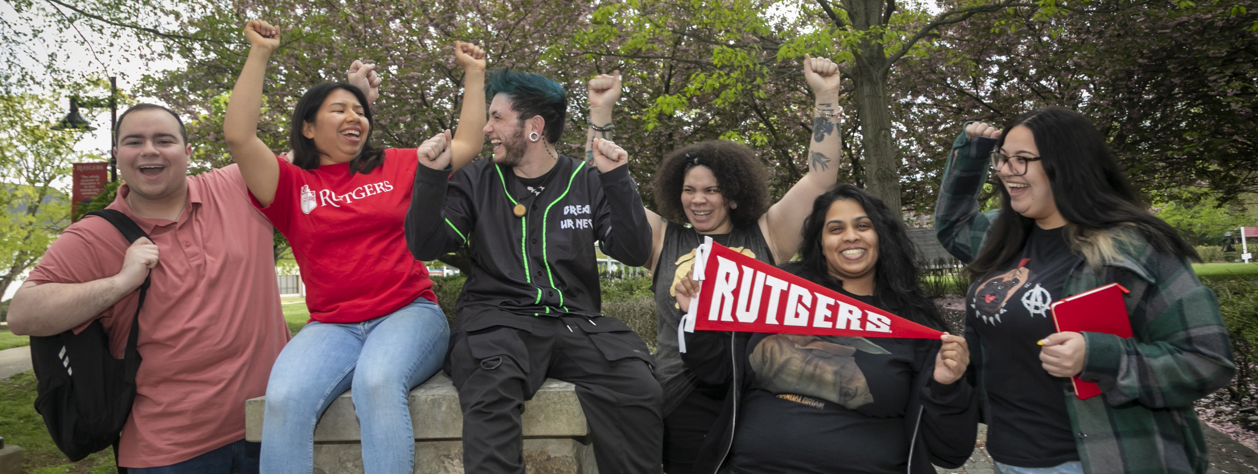 Students sitting on a stone wall